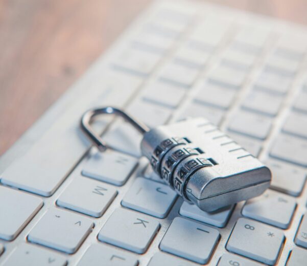 A combination lock rests on a computer keyboard.