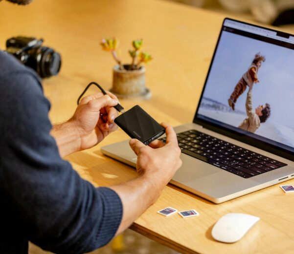 A man sitting at a table with a laptop and cell phone