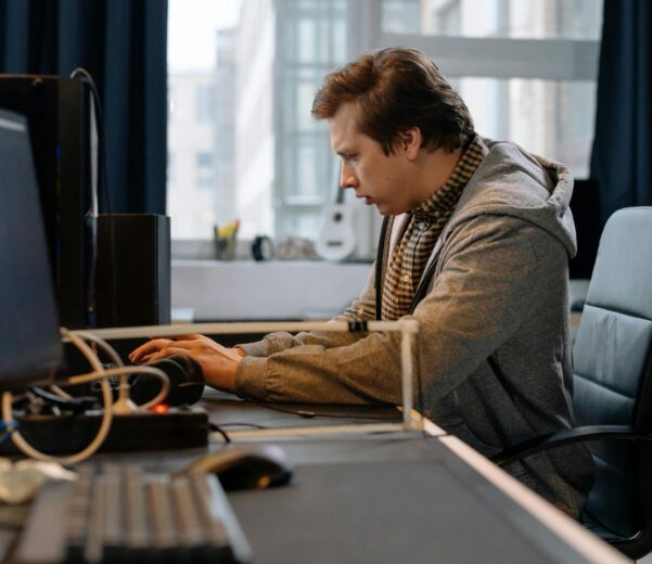 Free A concentrated professional working at a computer in a modern office setting. Stock Photo