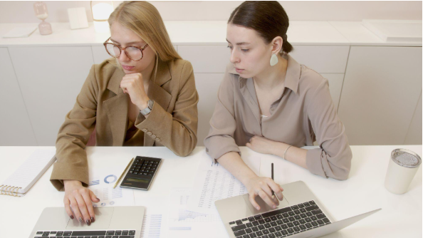 two women with laptops